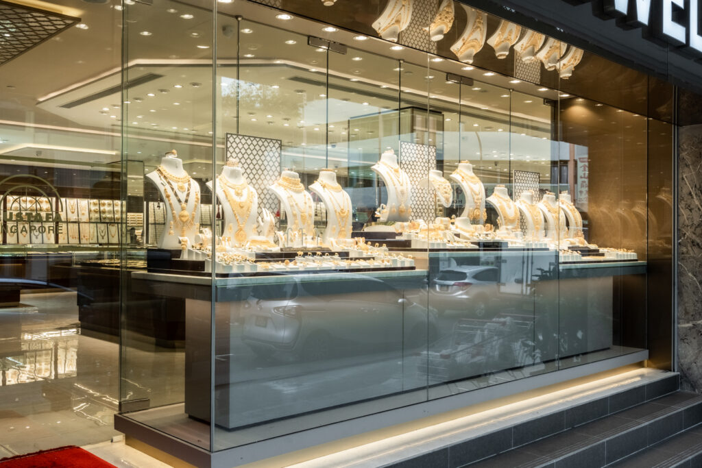 captures the wide, modern storefront of "Mustafa Jewellery," located inside a well-lit shopping mall or commercial complex. The storefront features an expansive glass facade that offers a clear, open view into the spacious interior of the showroom.